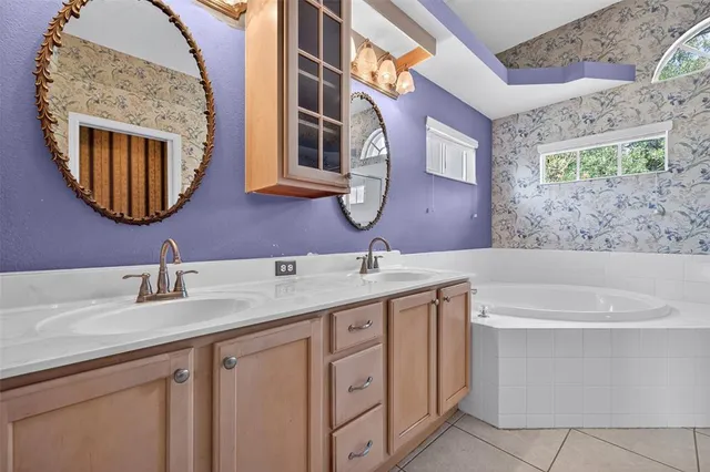 a bathroom with a granite countertop double vanity sink and mirror