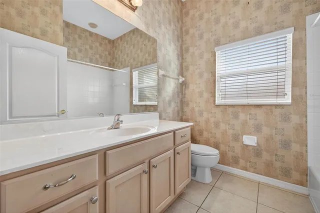 a bathroom with a granite countertop sink a toilet and a mirror