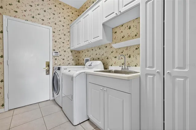 a utility room with cabinets washer and dryer
