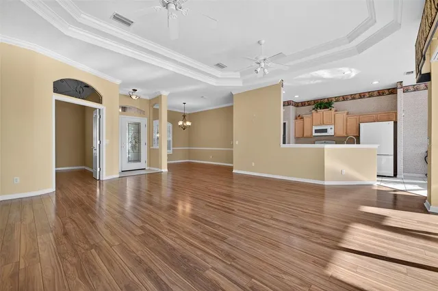 a view of a hallway with wooden floor and a kitchen
