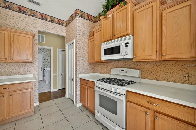 a kitchen with white cabinets and appliances
