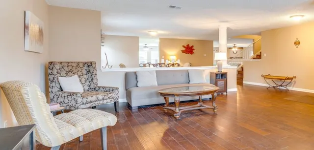 a living room with furniture and a wooden floor