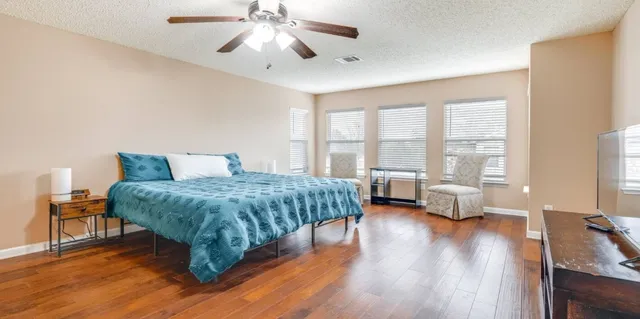 a bedroom with a large bed and a large window