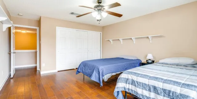 a bedroom with two beds and a ceiling fan
