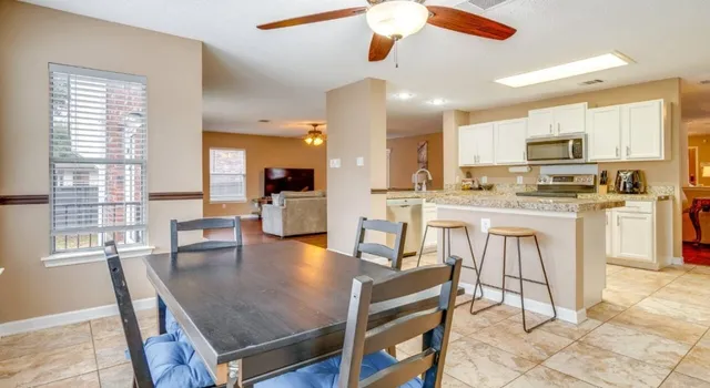 a dining room with stainless steel appliances kitchen island granite countertop a dining table chairs and view living room