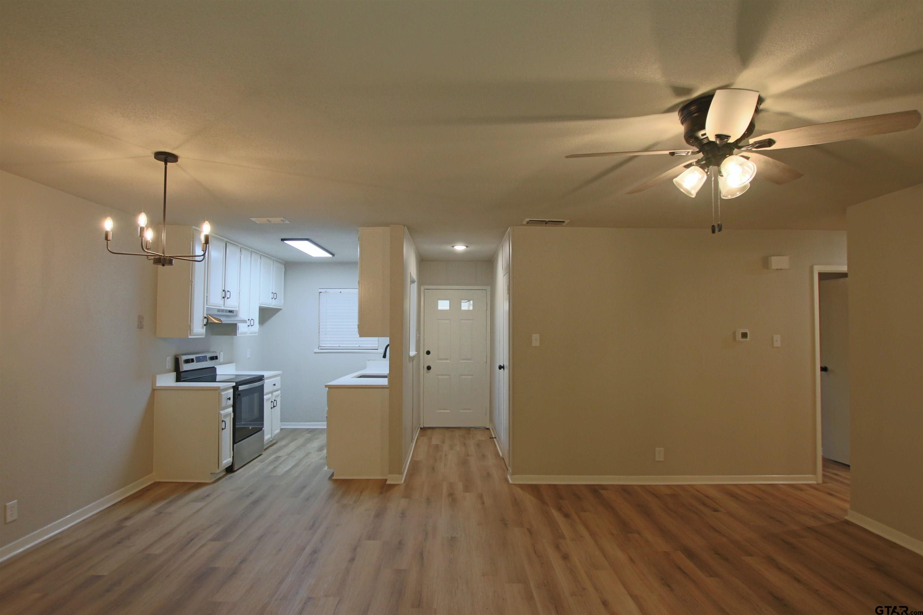 12336 Chapman Road Tyler, TX 75708 - Photo 2 of 19 a view of a kitchen with a sink and dishwasher a refrigerator with wooden floor