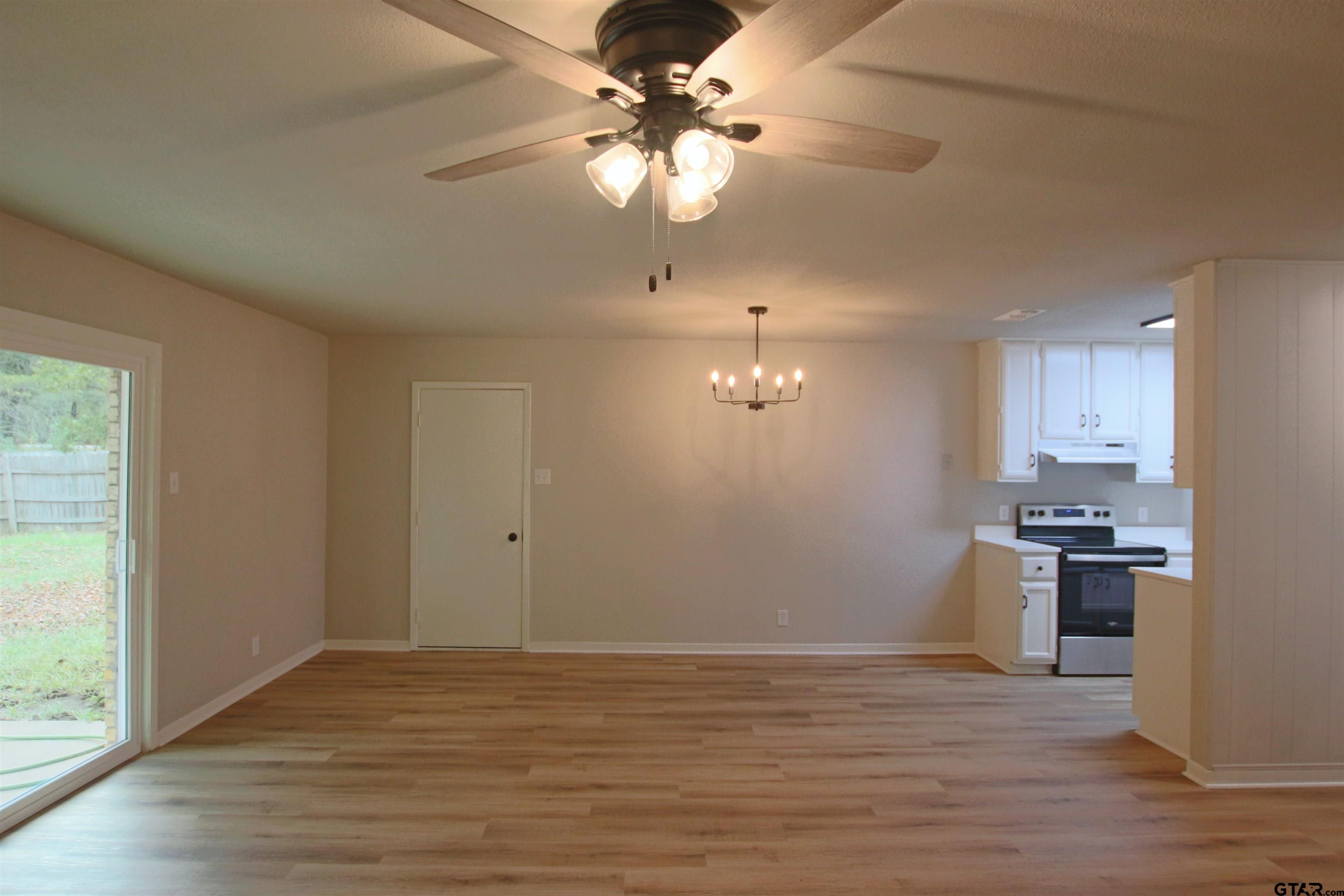 12336 Chapman Road Tyler, TX 75708 - Photo 7 of 19 a view of a kitchen with a stove wooden cabinets and wooden floor