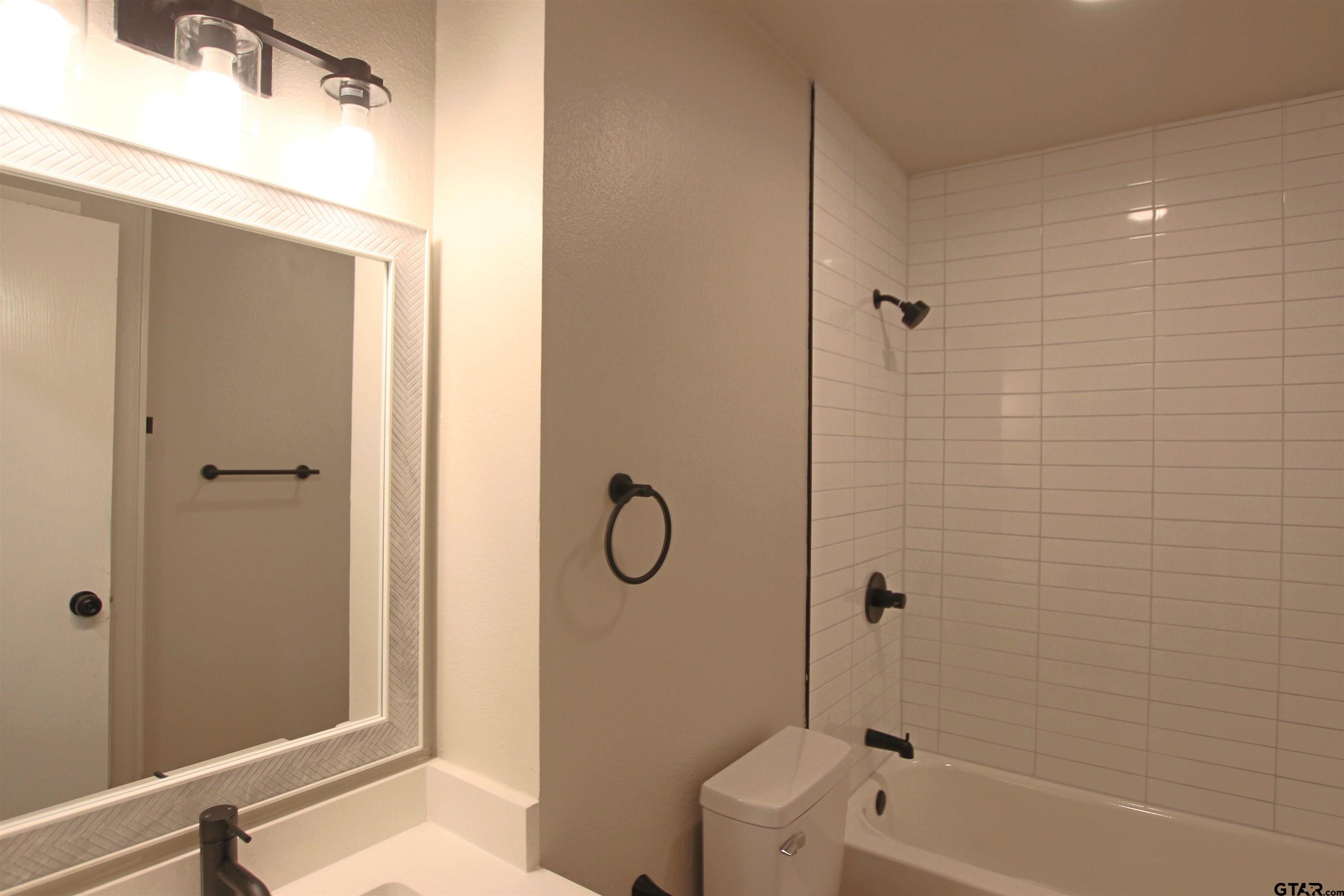12336 Chapman Road Tyler, TX 75708 - Photo 8 of 19 a bathroom with a granite countertop bathtub shower and toilet