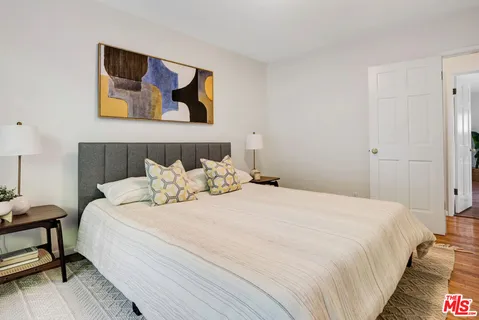 a bedroom with bed and painting on the wall