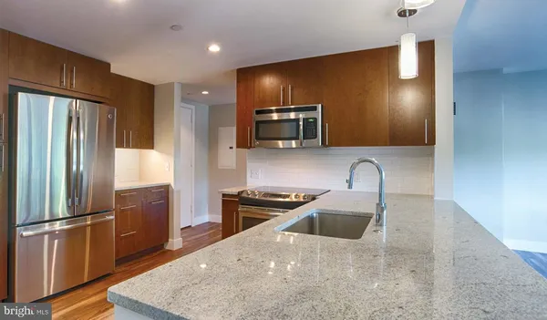 a kitchen with stainless steel appliances granite countertop a sink refrigerator and microwave