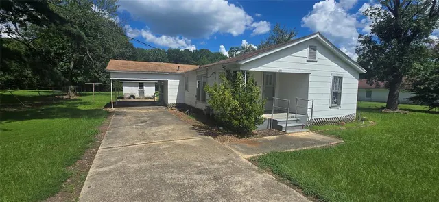a front view of a house with a yard and trees