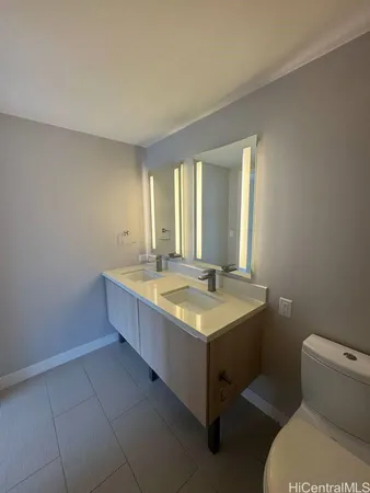 a bathroom with a granite countertop sink a toilet and mirror