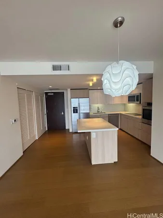 a living room with couches and kitchen view