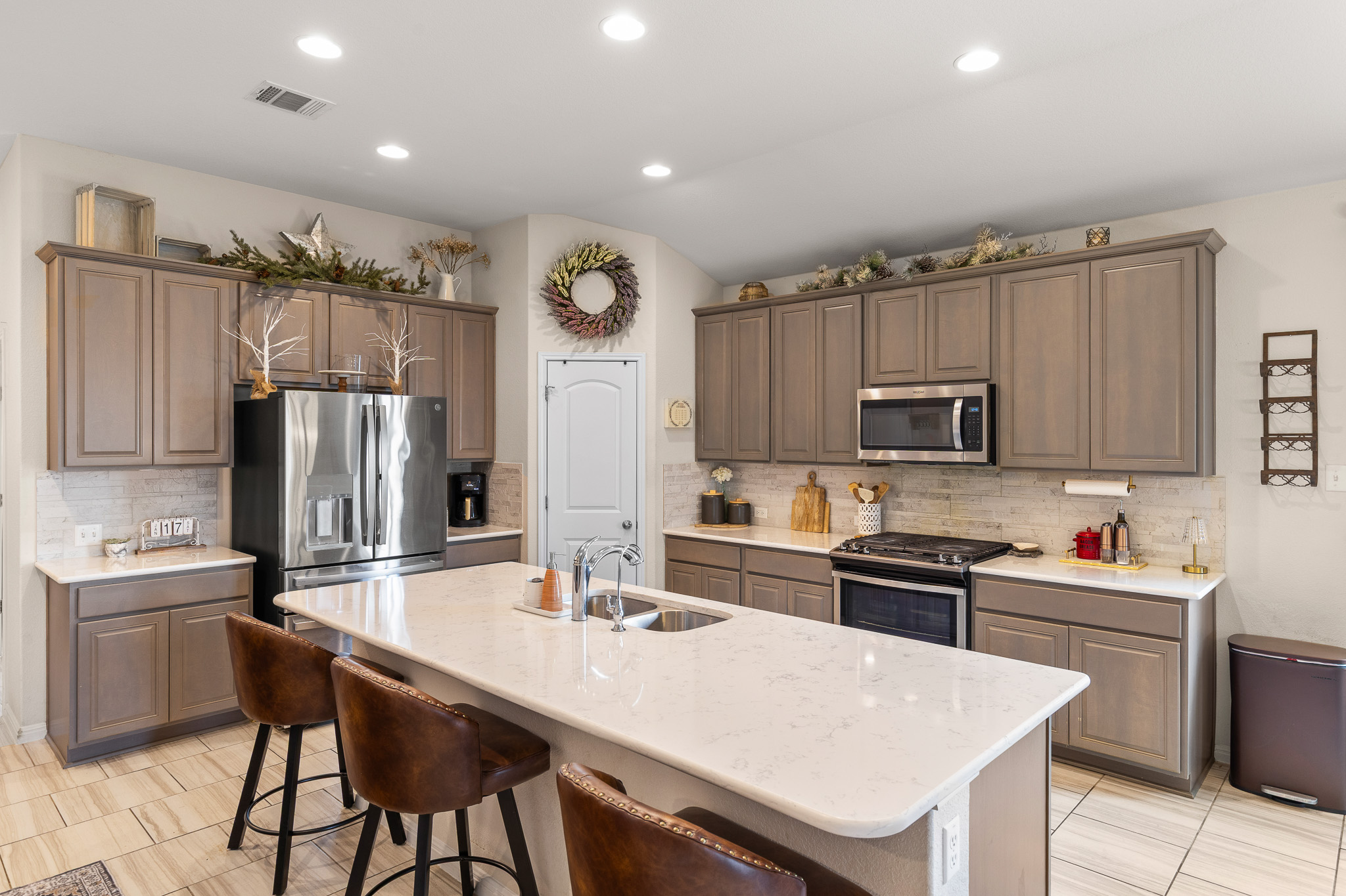 276 Finstown Street Hutto, TX 78634 - Photo 7 of 19 a kitchen with stainless steel appliances a sink a stove a refrigerator cabinets and a dining table