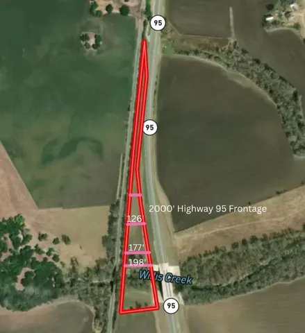 a view of a yard and car parked on the road