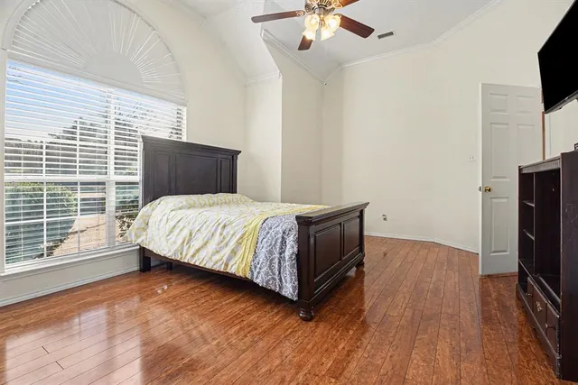 a bedroom with a bed and flat tv screen on the dresser