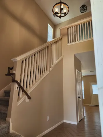 a view of staircase with lots of frames and a chandelier