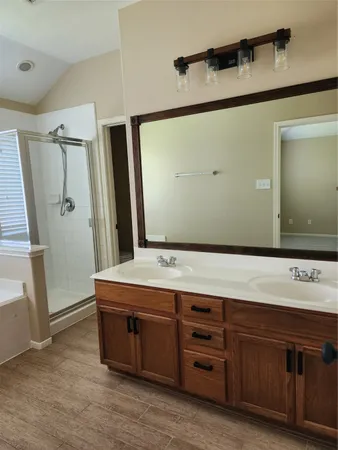 a spacious bathroom with a tub sink and mirror