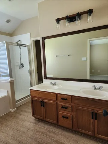 a spacious bathroom with a tub sink and mirror