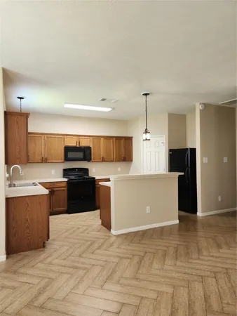 a large kitchen with kitchen island a sink dishwasher a stove and a refrigerator with wooden floor