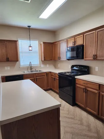 a kitchen with stainless steel appliances a sink dishwasher a stove top oven a refrigerator and cabinets