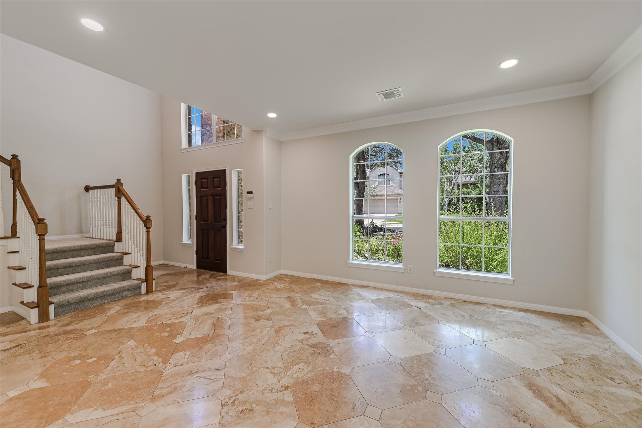 2849 Grimes Ranch Road Austin, TX 78732 - Photo 4 of 31 Enter into a grand foyer featuring striking arched windows, a high ceiling, and elegant tile flooring.