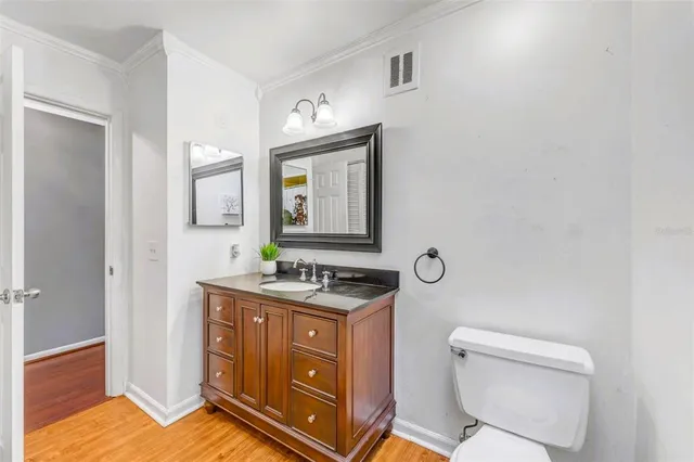 a bathroom with a granite countertop toilet sink and mirror