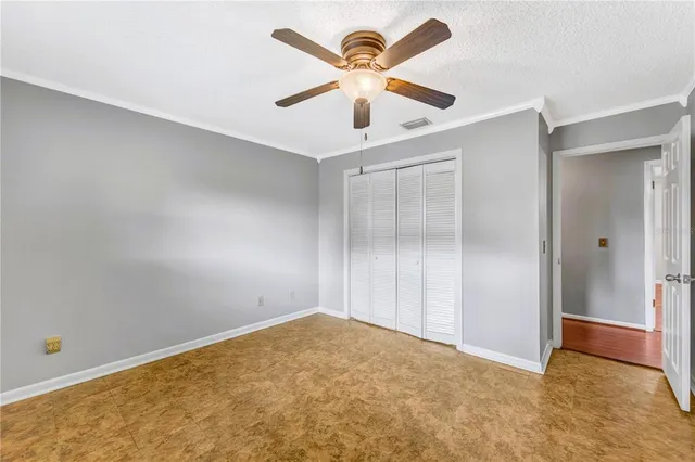 an empty room with closet and fan