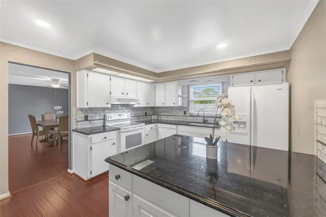 a kitchen with stainless steel appliances granite countertop a stove a sink and a refrigerator