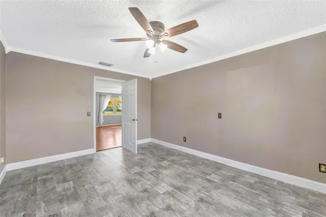 an empty room with closet and fan