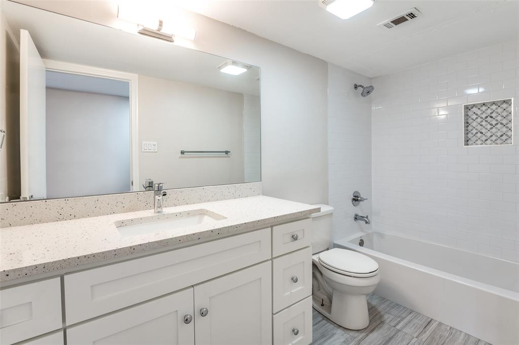 6315 Campbell Road, Unit 510 Dallas, TX 75248 - Photo 8 of 11 a bathroom with a granite countertop sink toilet a mirror and bathtub