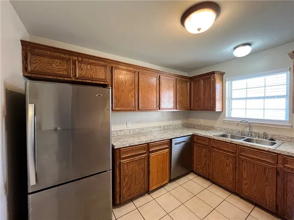 a kitchen with stainless steel appliances granite countertop a refrigerator and a sink