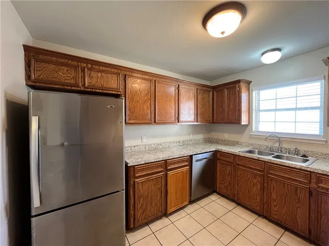 a kitchen with stainless steel appliances granite countertop a refrigerator and a sink