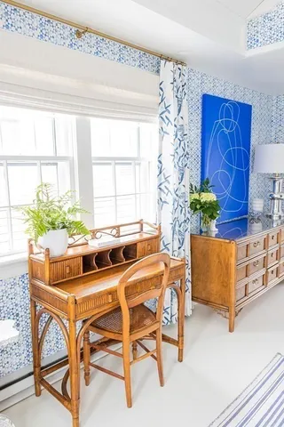 a white building with a bench and lawn chairs