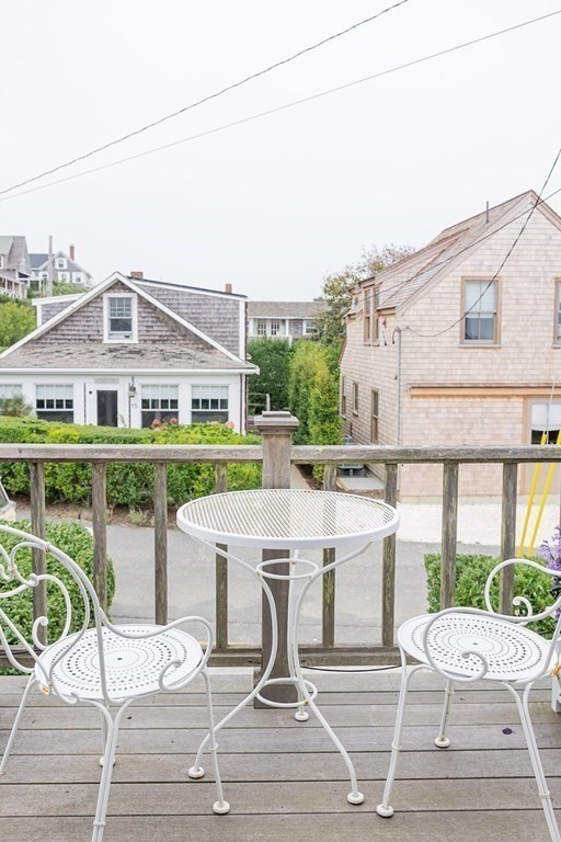 7 Bank Street Nantucket, MA 02554 - Photo 24 of 34 a white building with a bench and lawn chairs