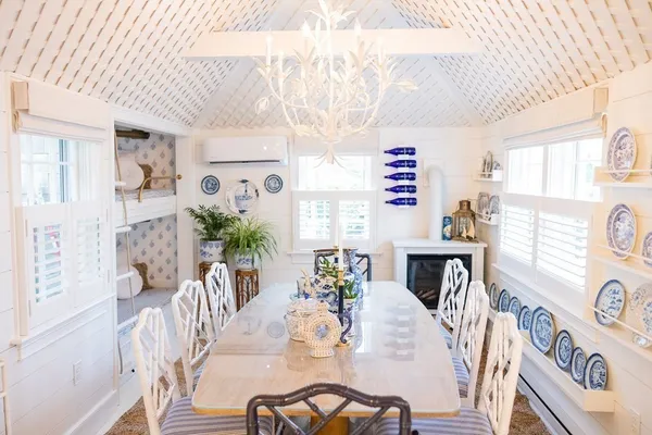 a view of a dining room with furniture a potted plant and wooden floor