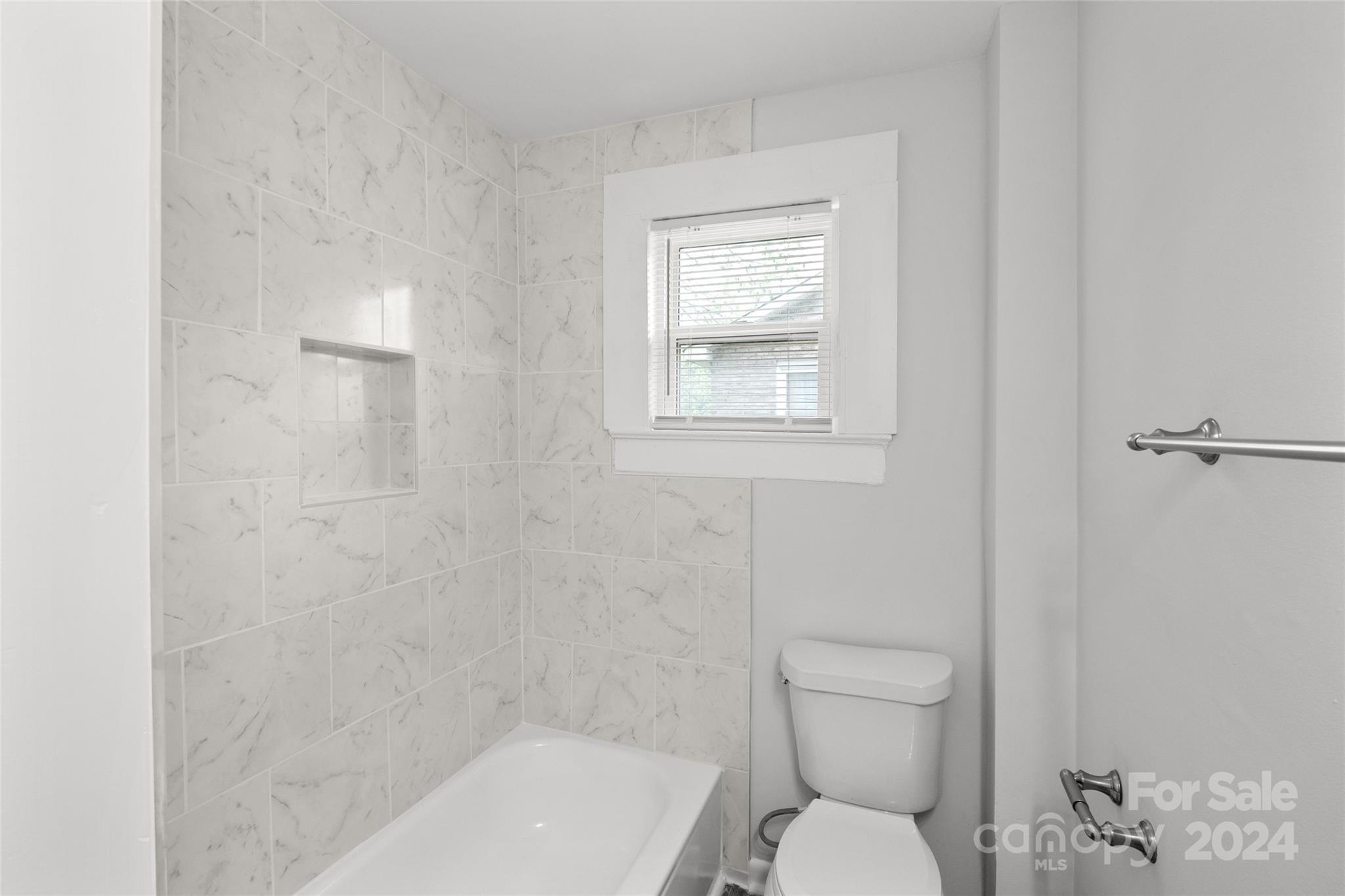 3106 Tuckaseegee Road Charlotte, NC 28208 - Photo 18 of 44 a white toilet sitting next to a bath tub