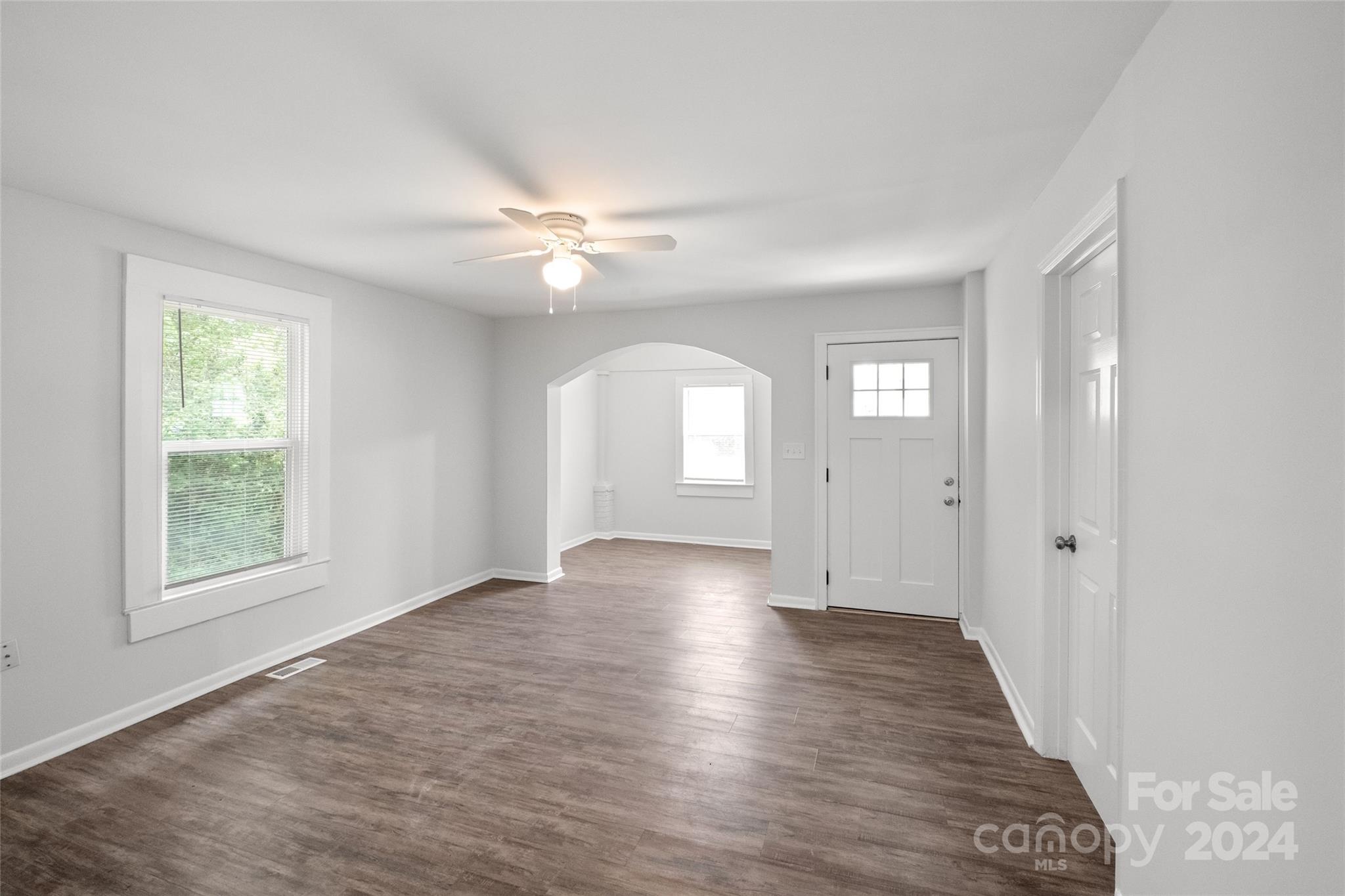3106 Tuckaseegee Road Charlotte, NC 28208 - Photo 5 of 44 an empty room with wooden floor fan and windows