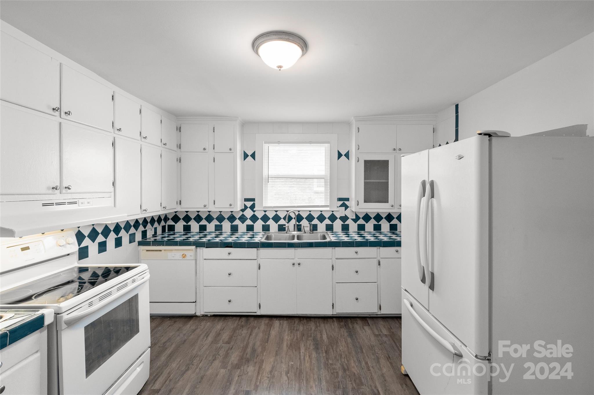 3106 Tuckaseegee Road Charlotte, NC 28208 - Photo 10 of 44 a kitchen with granite countertop a refrigerator a stove a sink and white cabinets