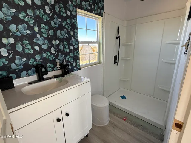 a bathroom with a sink a toilet and shower