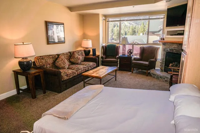 a bedroom with a bed furniture and a refrigerator