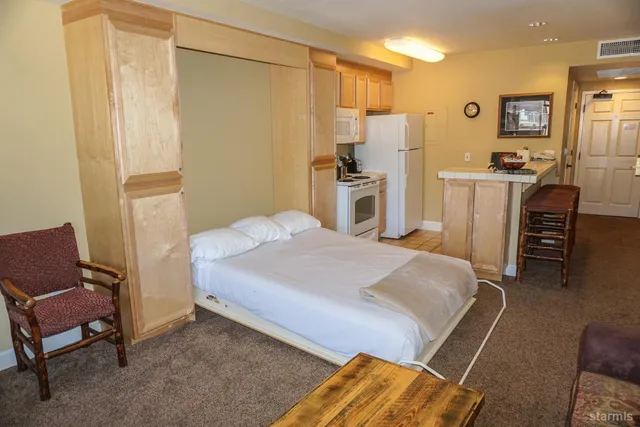 a bedroom with a bed a flat screen tv and a fireplace