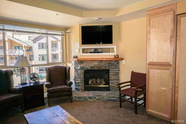 a living room with furniture a fireplace and a flat screen tv