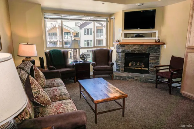 a living room with furniture a fireplace and a flat screen tv