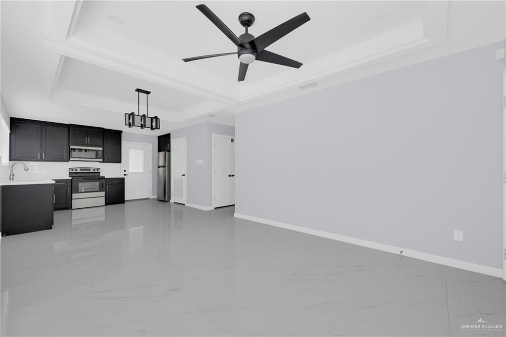 1612 Shadow Creek, Unit 1 Weslaco, TX 78596 - Photo 5 of 12 a view of a kitchen with a sink and dishwasher a refrigerator with wooden floor