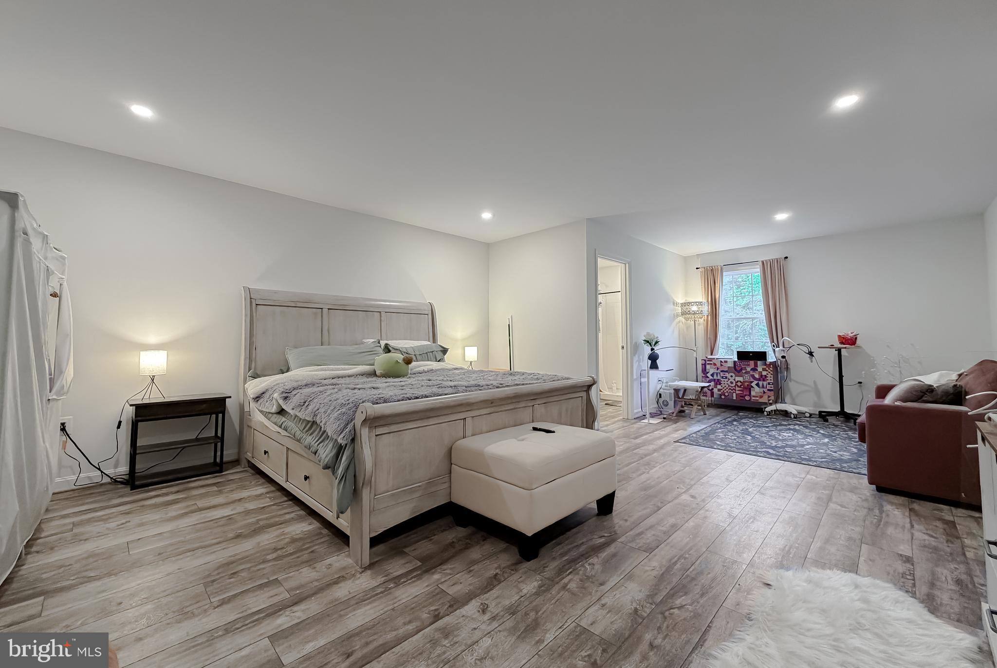 16146 Thomas Road Piney Point, MD 20674 - Photo 32 of 57 a spacious bedroom with a bed a table and a couch