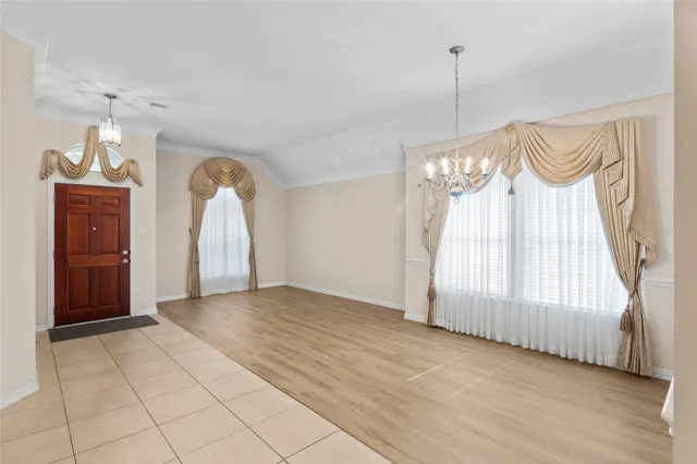 a view of a room with a chandelier and glass windows