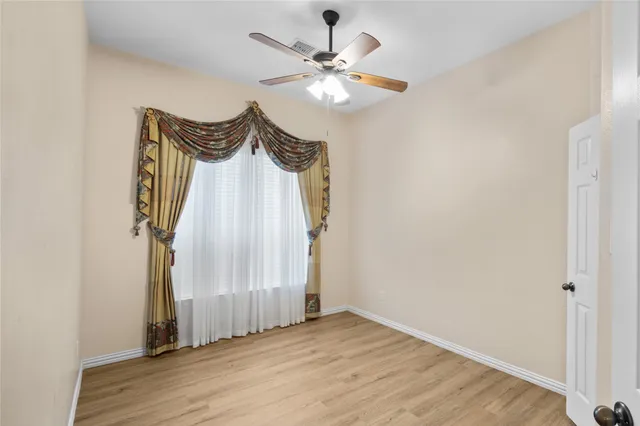 a view of a livingroom with wooden floor and a ceiling fan