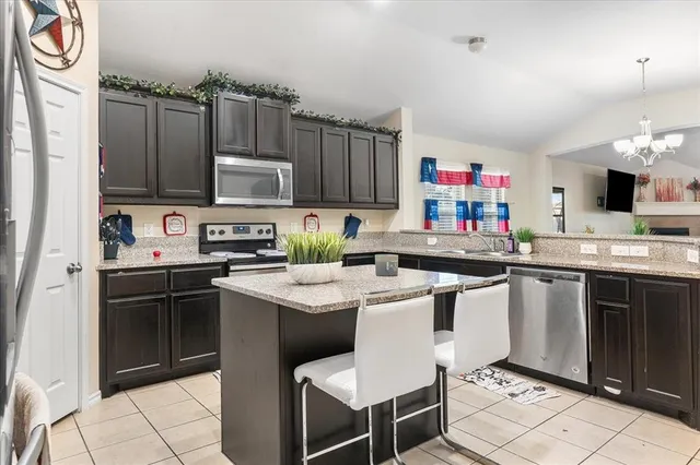 a kitchen with kitchen island granite countertop a sink stove and cabinets