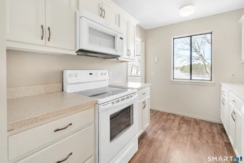 a kitchen with stainless steel appliances granite countertop a stove and a white cabinets
